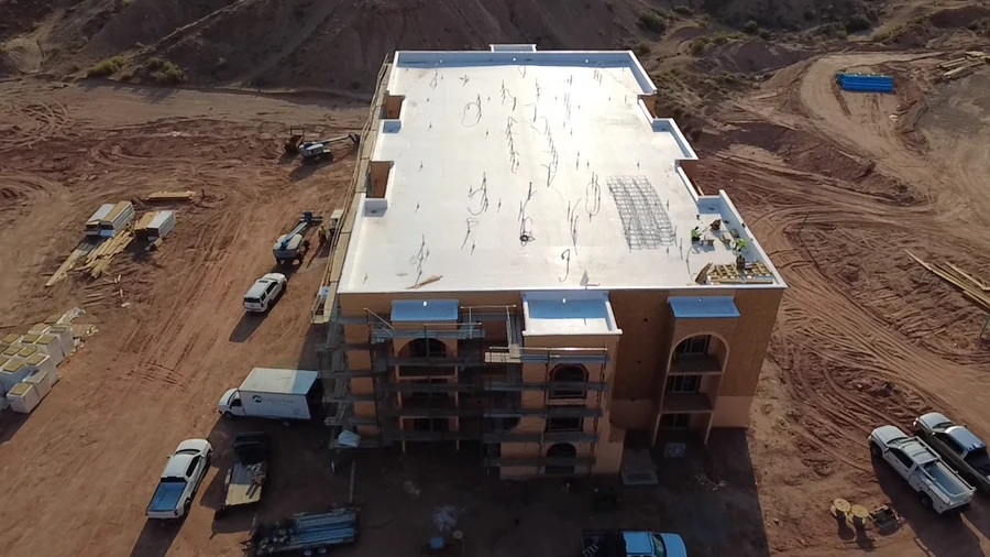 Aerial construction photograph looking over the roof toward the entry end of the apartment building.